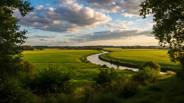 Rolling Green Fields and a River Under a Dramatic Sky