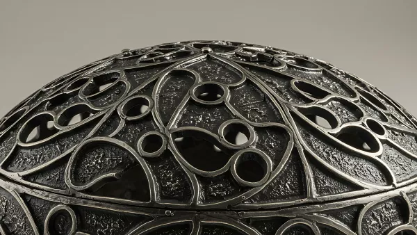 Intricate Silver Filigree Design on a Dark Textured Surface