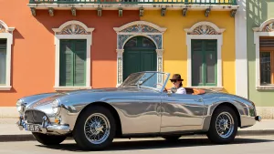 Chrome Classic Convertible Cruising Past Colorful Buildings