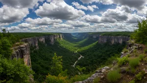 Verdant Valley Vista Majestic Cliffs and Cloudy Skies